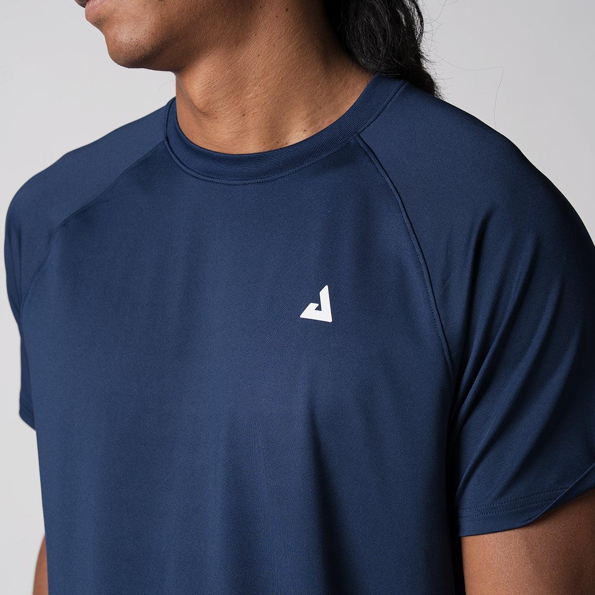 Mann trägt navyblaues Funktions-T-Shirt mit weißem Logo auf der Brust.