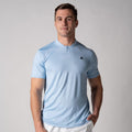 Mann trägt hellblaues, kurzärmeliges Sportshirt mit Stehkragen und kleinem schwarzem Logo auf der Brust.
