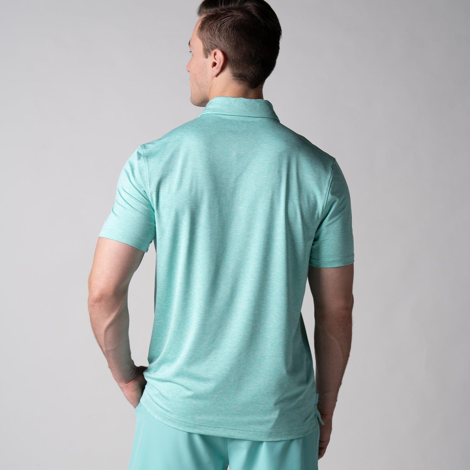 Mann von hinten in hellgrünem, kurzärmeligem Poloshirt und passender Hose vor neutralem Hintergrund.