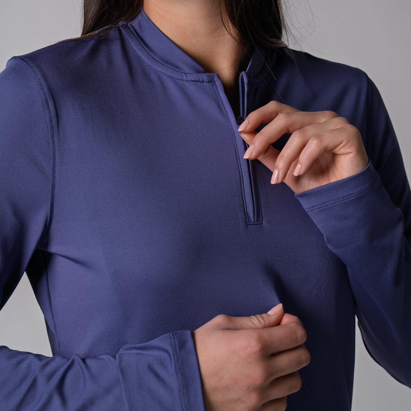 Frau zieht Reißverschluss eines langärmligen, dunkelblauen Sportshirts hoch.