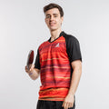 Junger Mann in rotem und schwarzem JOOLA Tischtennis-Trikot hält Tischtennisschläger.