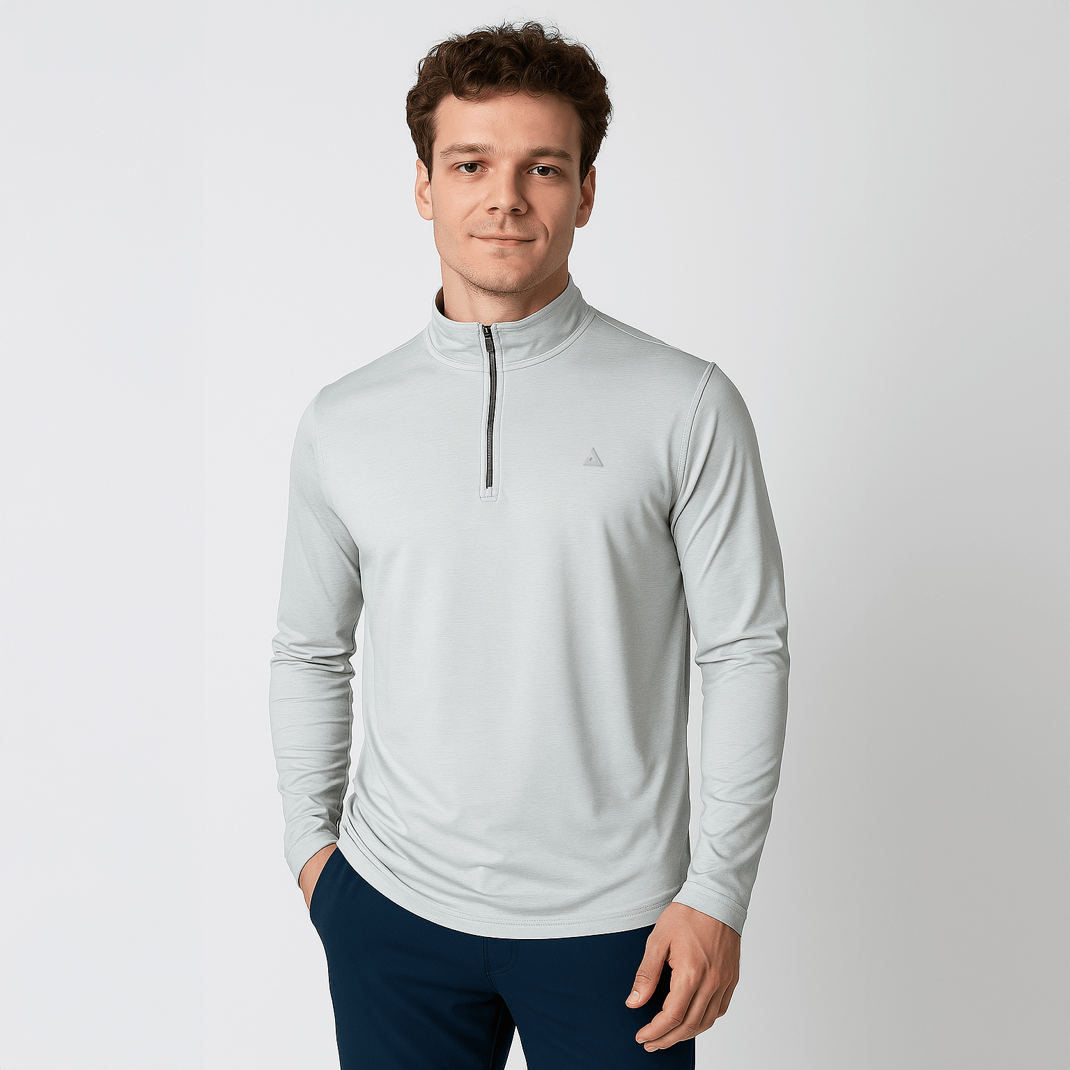 Mann trägt hellgraues Langarmshirt mit halbem Reißverschluss und Stehkragen, kombiniert mit dunkelblauer Hose.